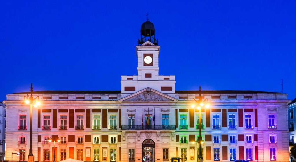 La Comunidad iluminó la Real Casa de Correos con la bandera arcoíris por el Día Internacional del Orgullo LGBTI