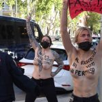 Activistas de Femen protestan con el torso desnudo a las afueras del colegio en el que vota Monasterio